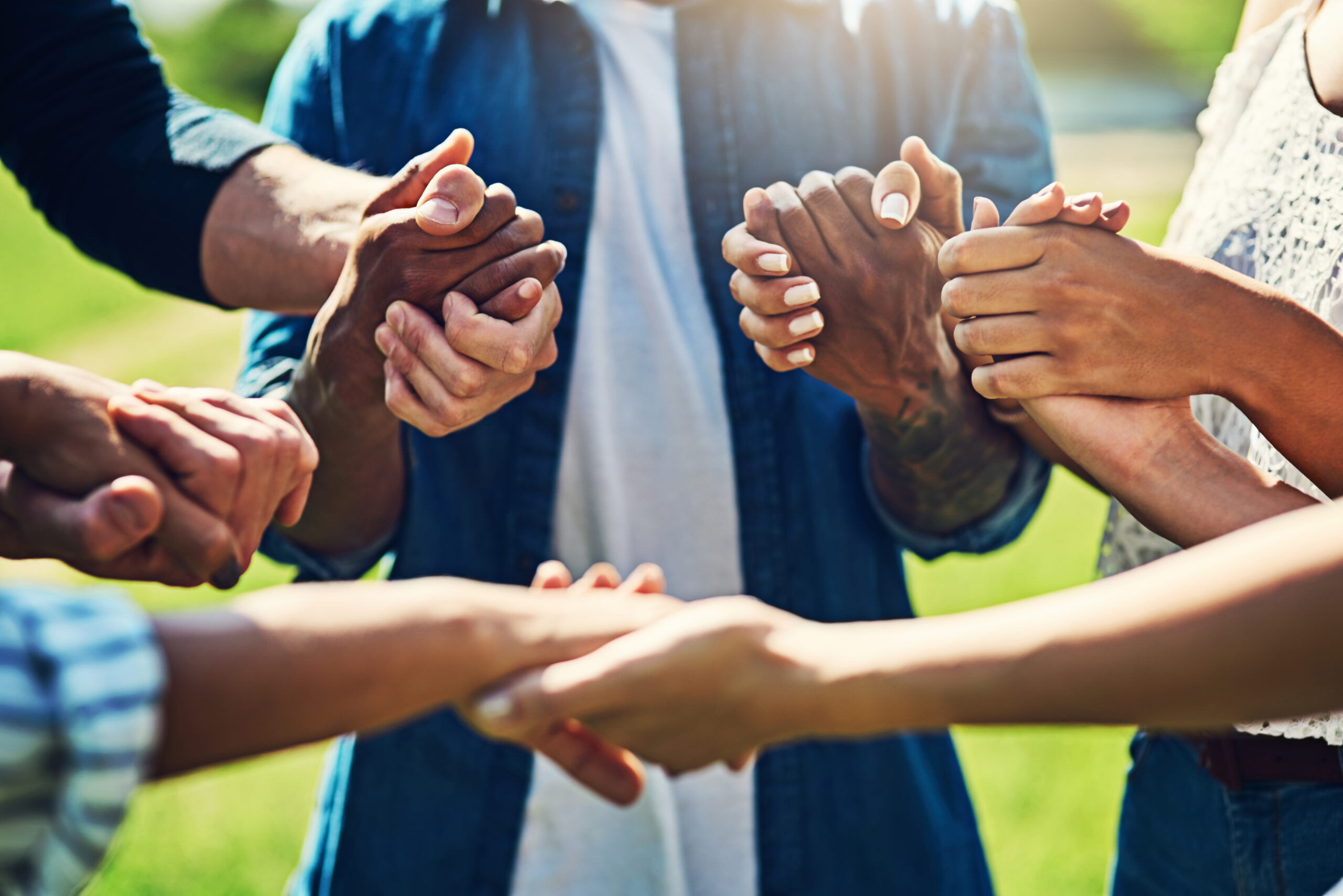 Friends, holding hands and people with group in outdoor therapy for hope, empathy or faith. Solidarity, circle and person in counseling for addiction, mental health or support with trust or kindness